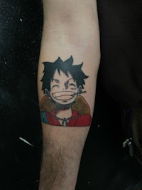 a tattoo of an anime character on a forearm